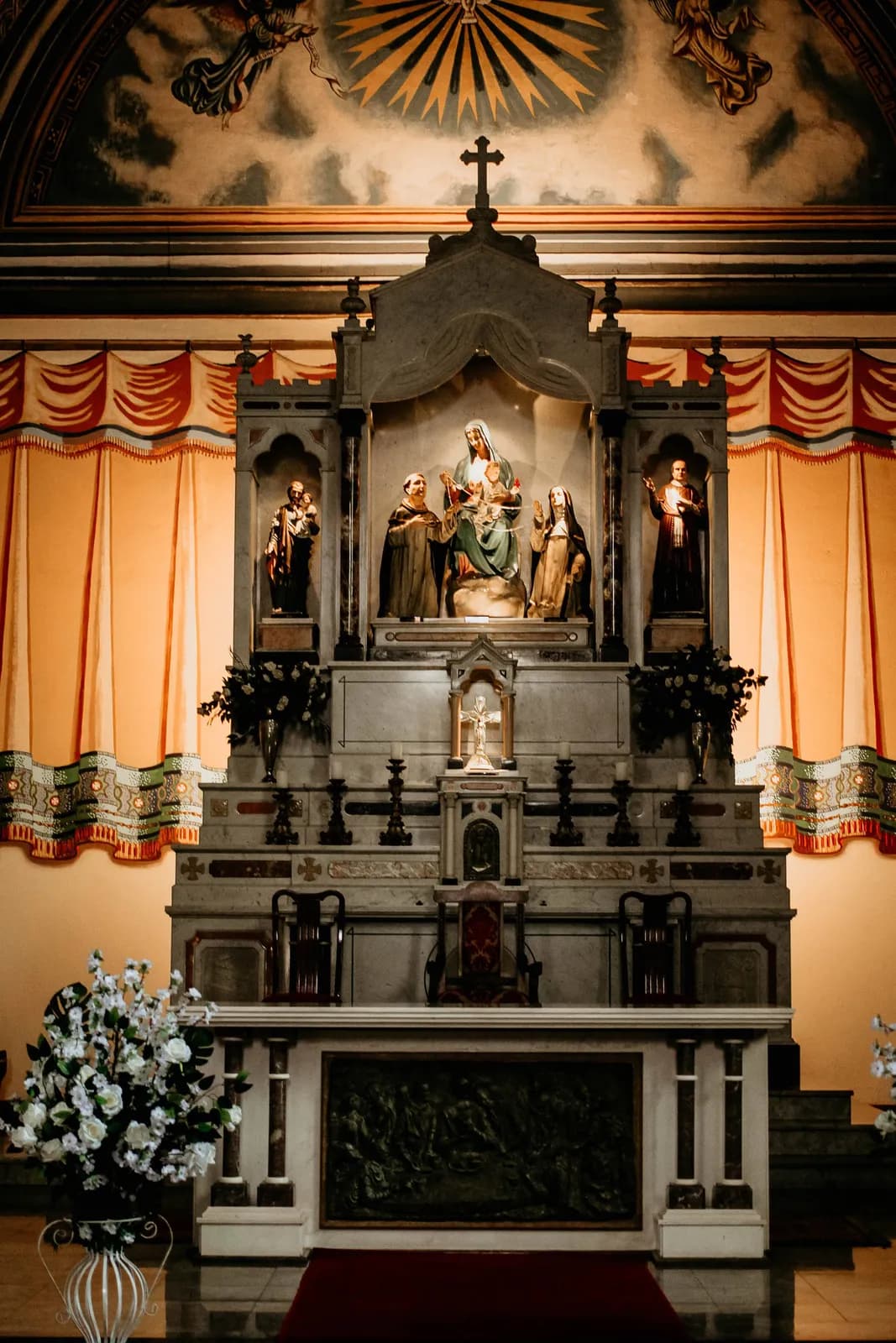 A church altar framed by statues of the saints.