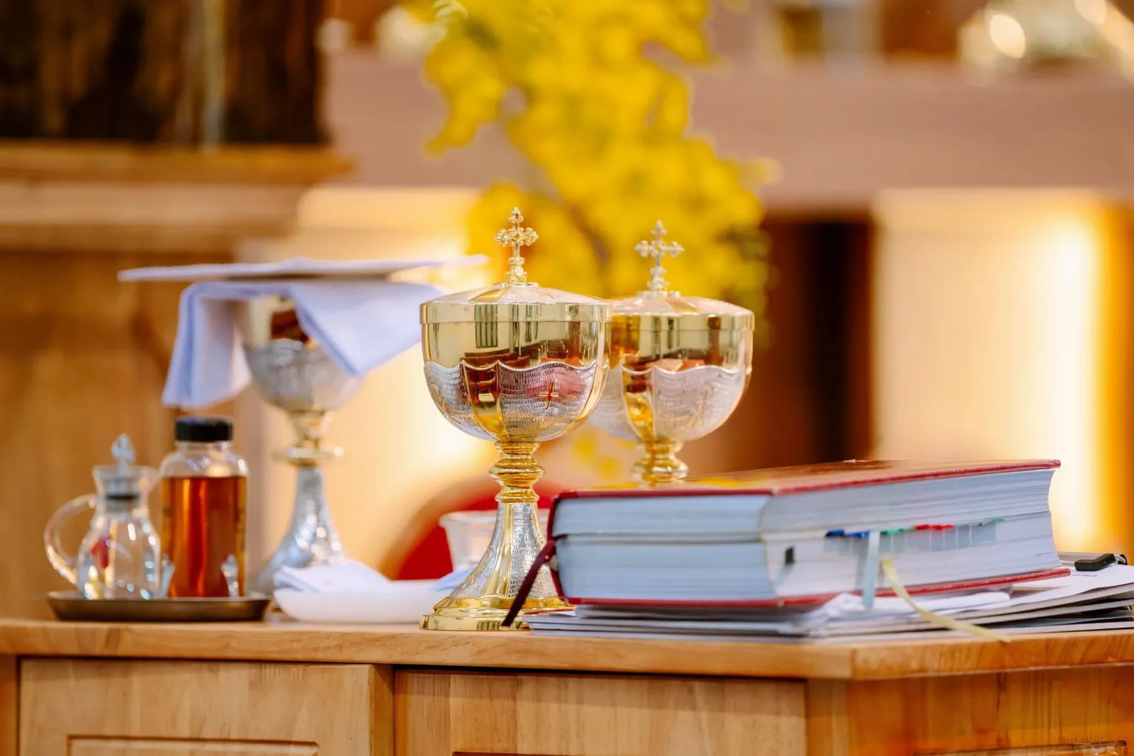 Golden chalices and a ciborium set upon the altar beside the Word.