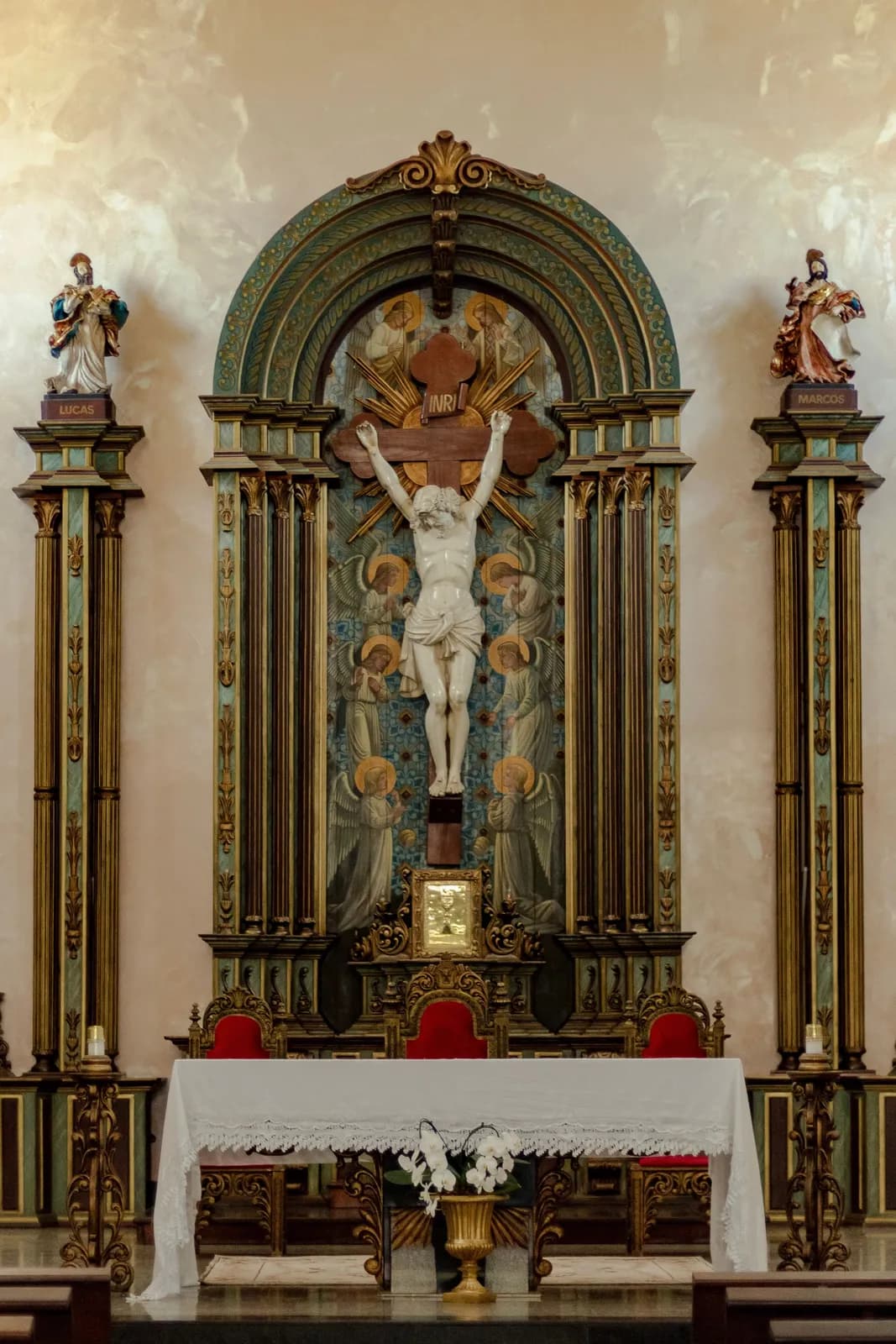 An ornate altar reredos crowned with a crucifix.