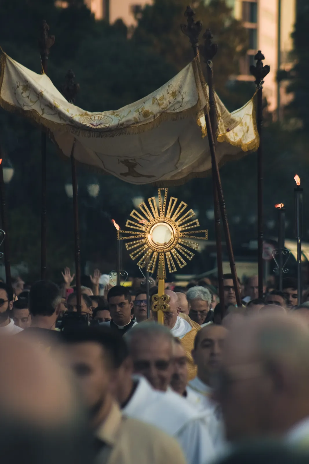 A monstrance carried beneath a canopy in a Corpus Christi procession.