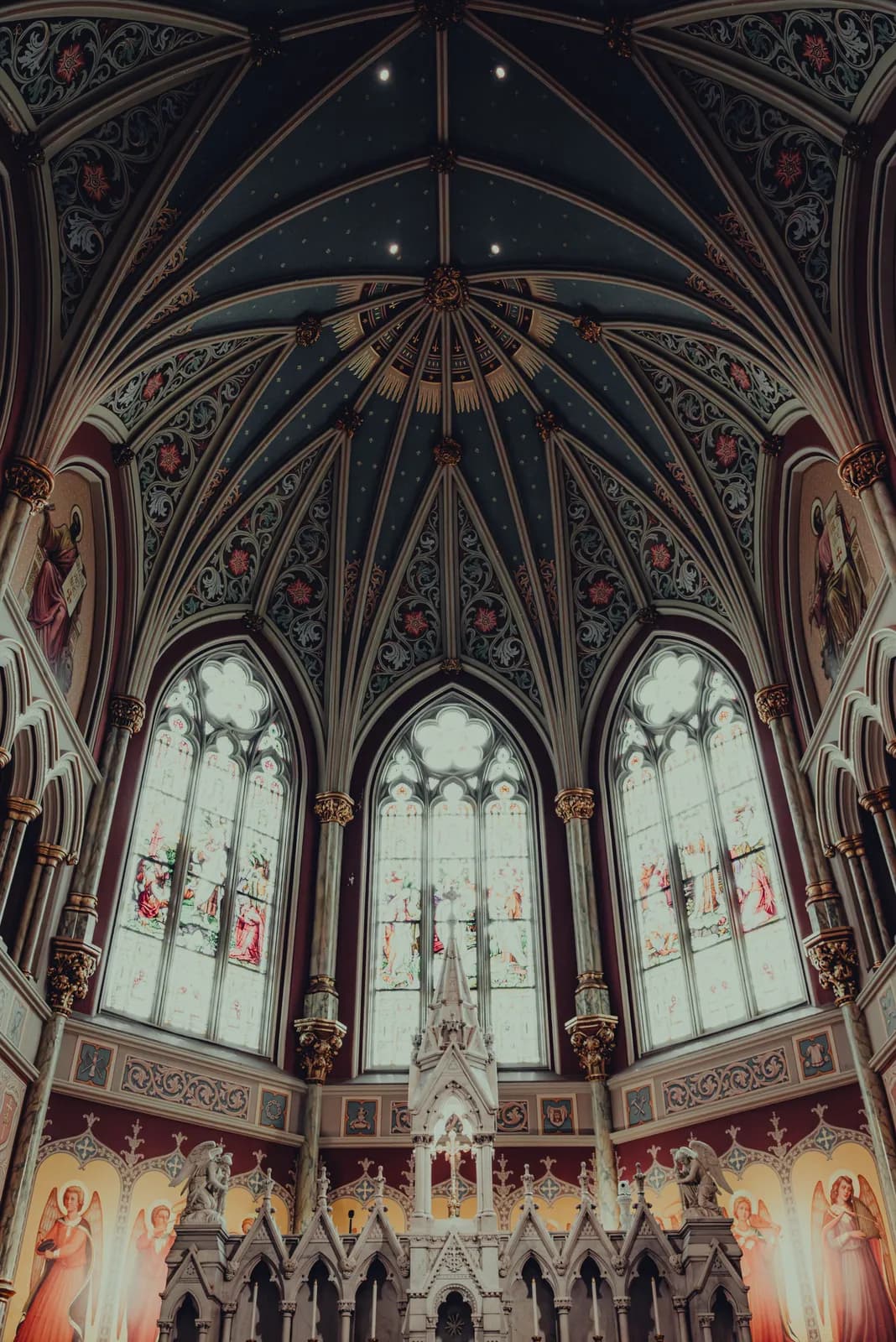 A Gothic cathedral ceiling and stained-glass windows.