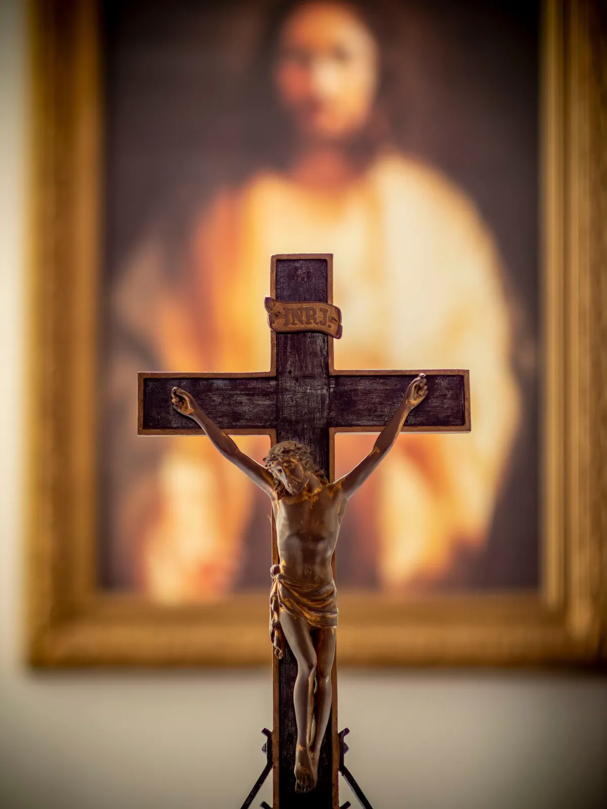 A crucifix lit from behind against a warm glow.