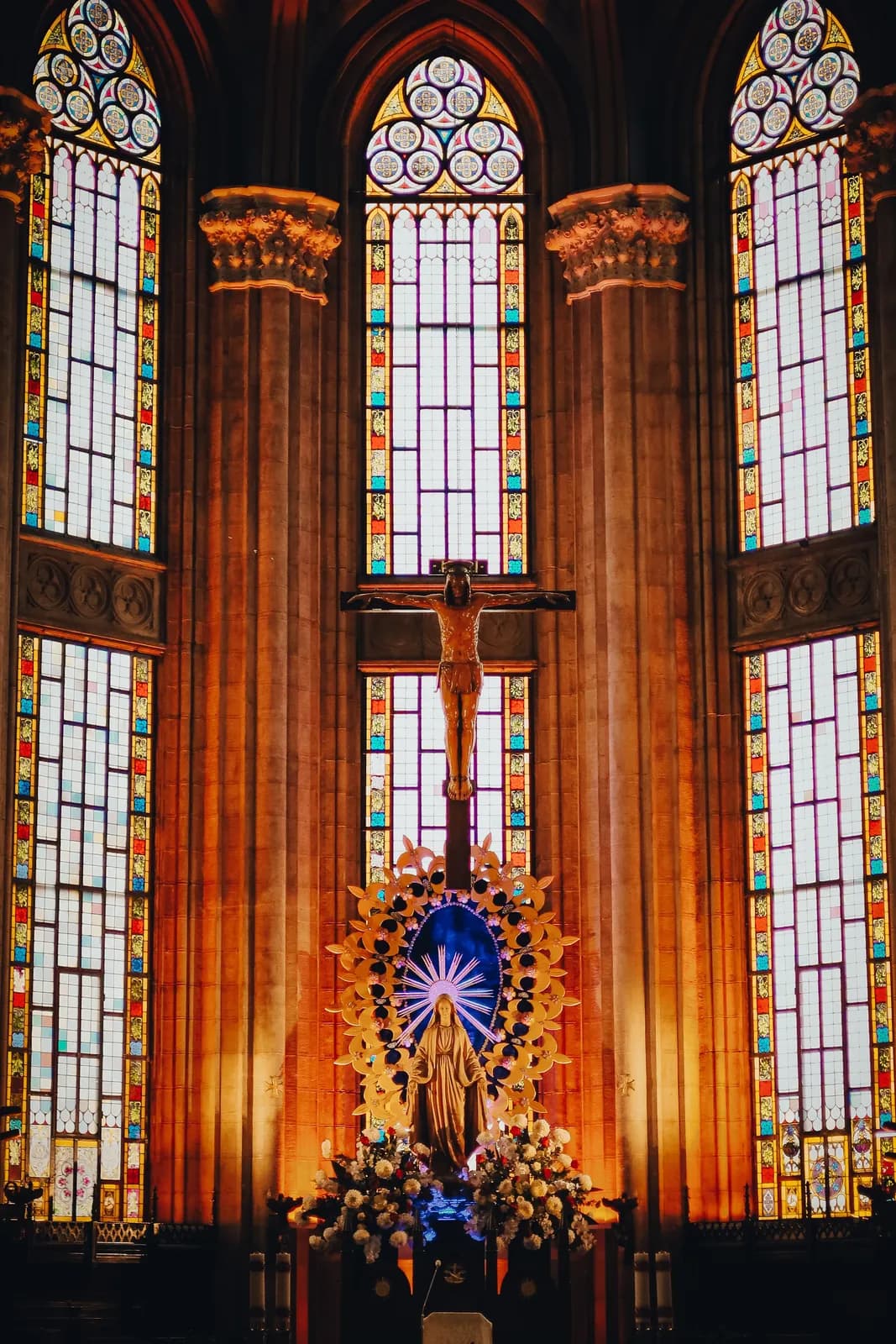 A crucifix set within a stained-glass window.