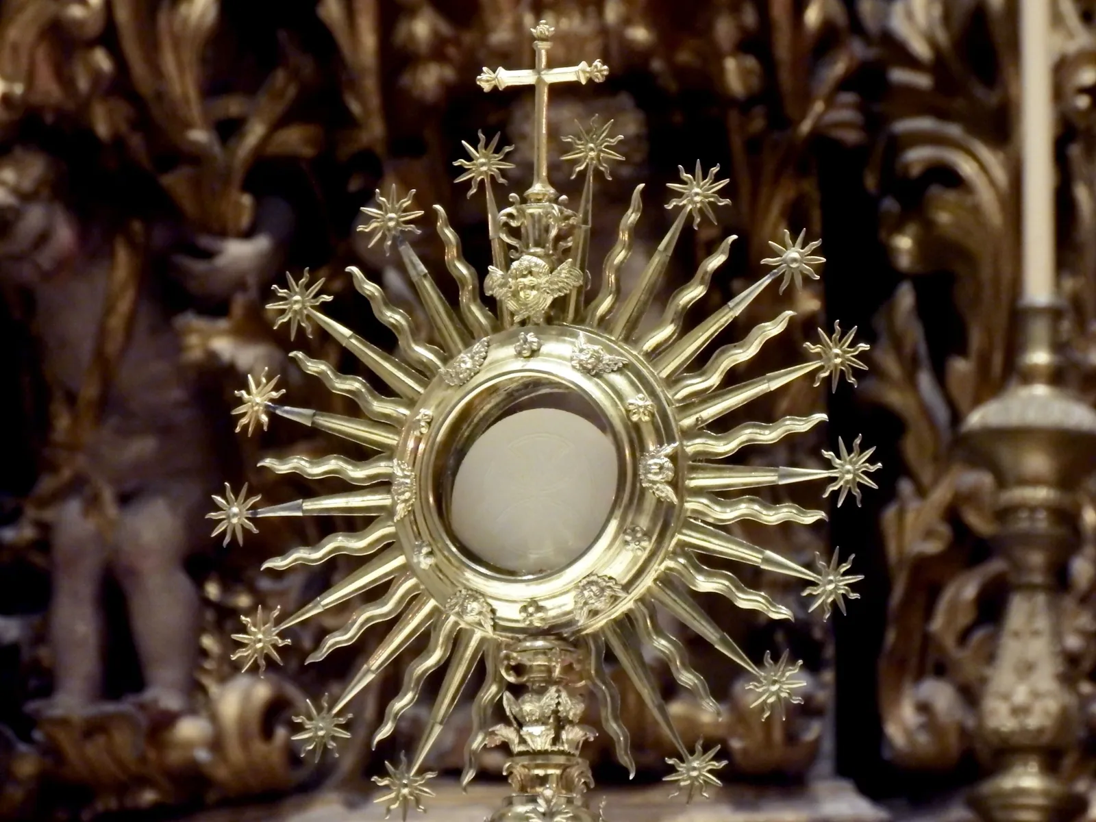 A golden monstrance with radiating sunburst rays.