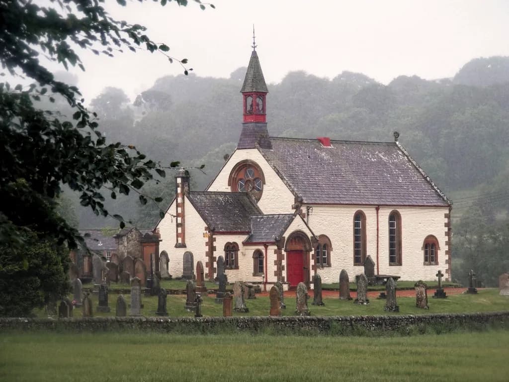 A white country church beside its churchyard.